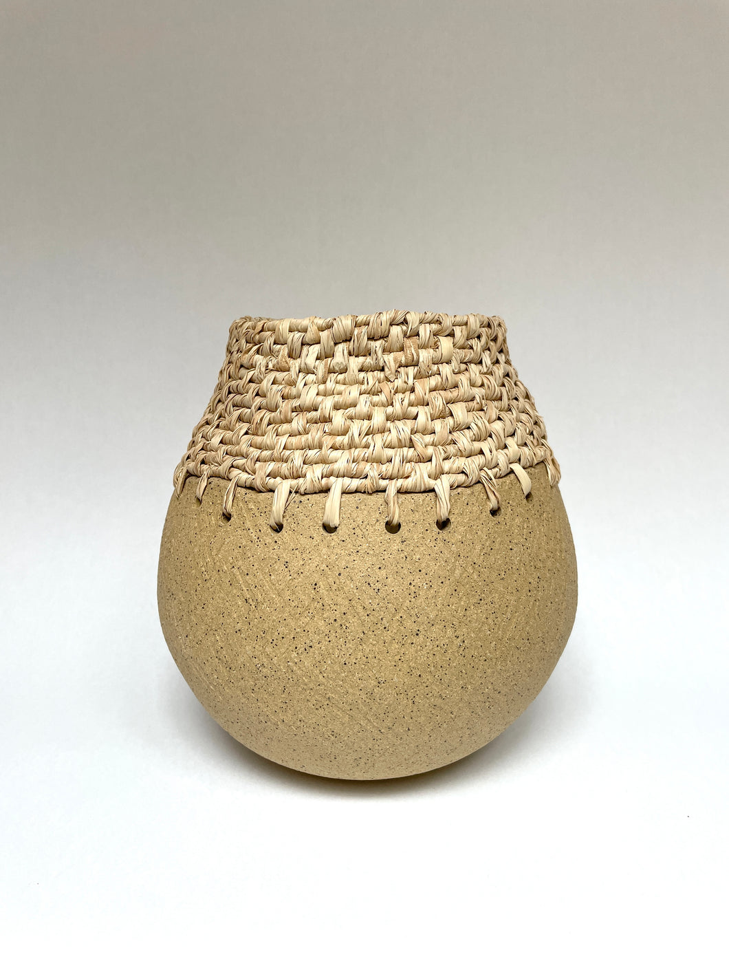 Handbuilt vase with raffia weaving